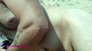 Piękność masturbuje się na plaży jednocześnie wachlując twardego kutasa swojego przyjaciela na zewnątrz