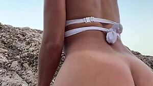 Behaarte Schlampe reizt mit Analplug am Strand