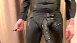 Trägt Latex-Hülle mit riesiger Penis-Verlängerung