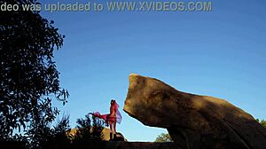 ब्रूनेट बिग टिट्स वाली पत्थर पर खड़ी आउटडोर प्लेइंग