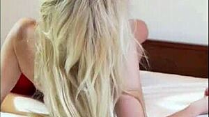 Odette cavorts on red bed playing with petite blonde pussy and natural tits