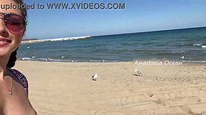 Mooie meid flasht blote borsten topless op openbaar strand