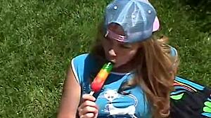 Teen Little April rubs clit outdoors while sucking popsicle