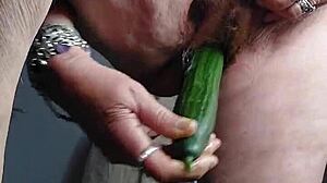 German granny casually stuffs her hairy pussy with a cucumber for solo fun.