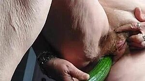 Old granny uses a cucumber to pleasure her hairy pussy in a homemade scene