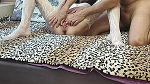 Wife in white stockings relaxes in front of her husband