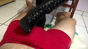 Tall couple in long leather boots, she gives footjob until he cums in pants.