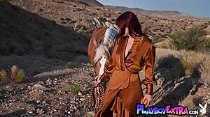 Petite redhead beauty Odette Fox rides horseback outdoors, stripping to reveal big natural tits and pussy.