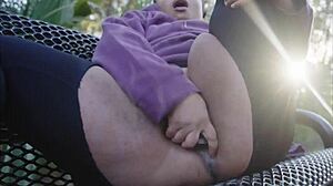 Ebony slut pounds pussy with dildo on public bench