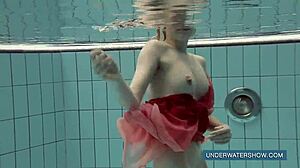 Brunette teen Katya Okuneva poses in red dress by the pool