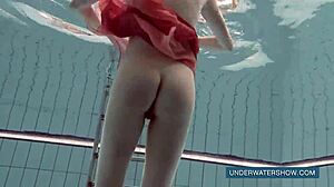 Brunette teen Katya Okuneva poses in red dress by the pool