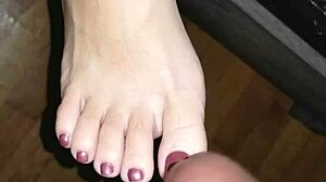she strokes his throbbing cock between her creamy toes until feet explode