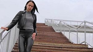 Brunette in tight leather leggings, high heels, and biker jacket dominates outdoors.