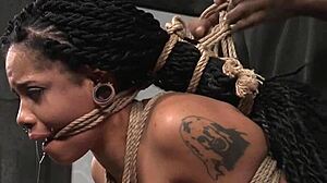 suspended ebony slave bound in garage for rough bdsm punishment