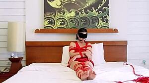Sofi lies bound on bed with tight red ropes hugging her curves part 2