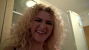 See this curly blonde flashing her pretty pussy solo in the kitchen