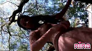 Lesbian Nina Strip Off Showing Natural Tits And Shaved Pussy In Tree