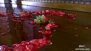 Cute bare feet squeeze juicy strawberry closeup