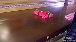 Cute bare feet squeeze juicy strawberry closeup