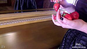Cute bare feet squeeze juicy strawberry closeup