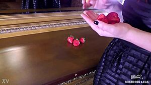 Cute bare feet squeeze juicy strawberry closeup