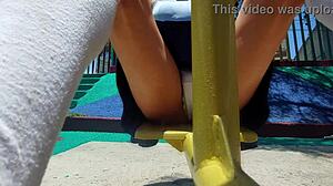 Young latina shows panties under skirt while walking in the park