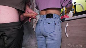 Maid washes dishes in kitchen wearing jeans