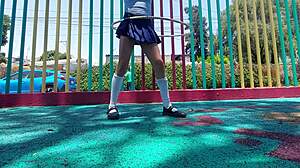 Young latina shows panties under skirt while walking in the park