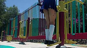 Young latina shows panties under skirt while walking in the park